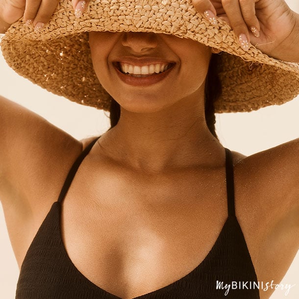 Femme heureuse portant un chapeau de plage de Bikini Village